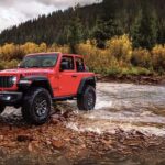 Red 2024 Jeep Wrangler Rubicon in a river