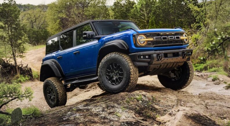 A blue 2025 Ford Bronco Raptor for sale parked off-road.