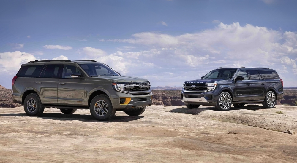 A green 2025 Ford Expedition Tremor and a blue Expedition Platinum parked off-road.