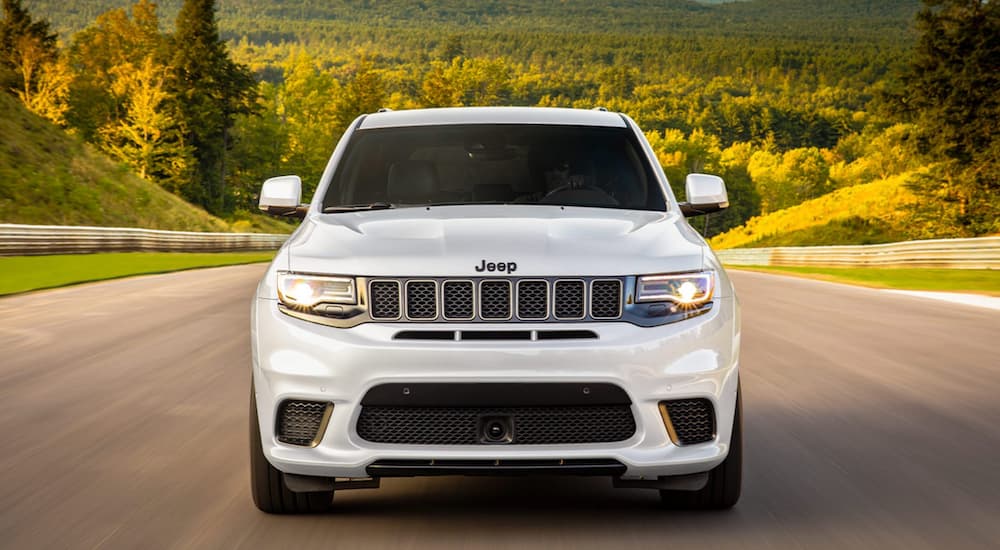 A white 2020 Jeep Grand Cherokee driving on an open road.