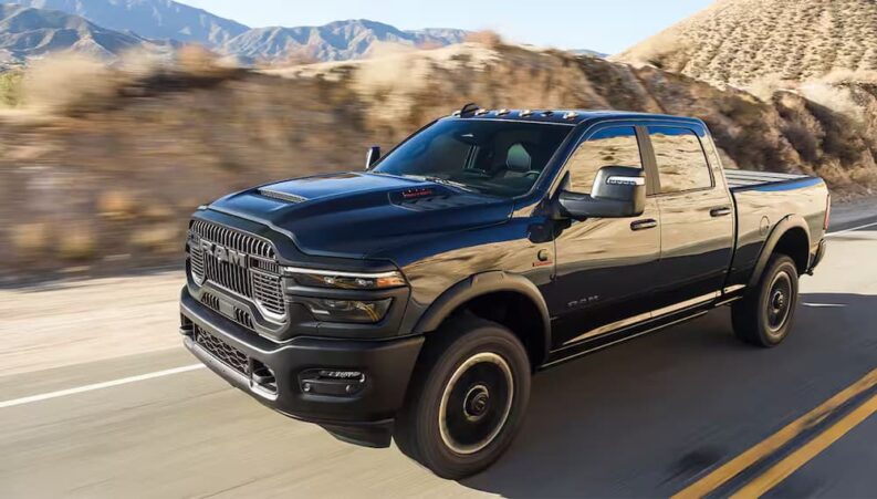 A black 2024 Ram 2500 HD Rebel driving to view used trucks for sale.