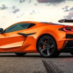 An orange 2025 Corvette Z06 parked on a race track