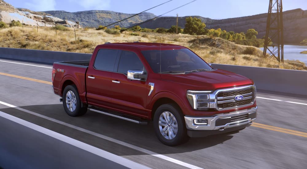 A red 2025 Ford F-150 driving down a highway