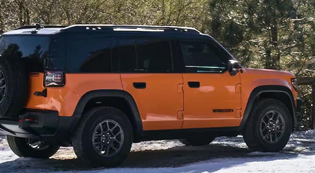 A black and orange 2026 Jeep Recon EV parked on snow.