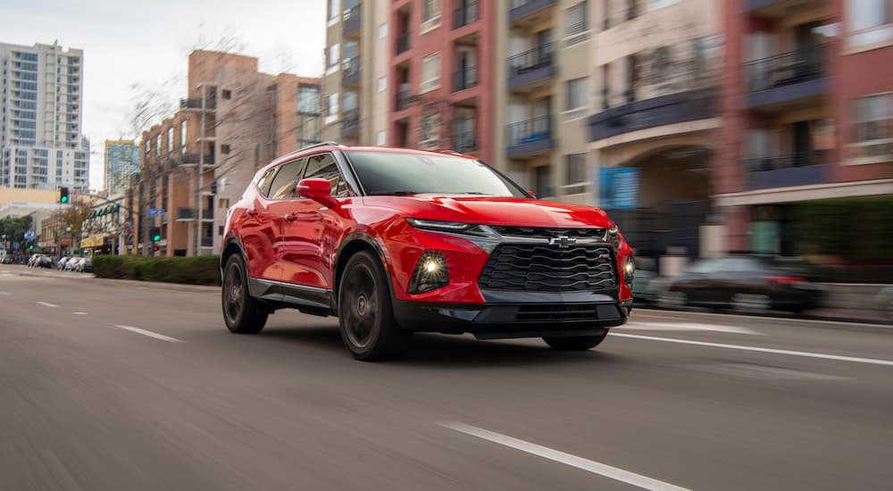 A red 2019 Chevy Blazer RS driving to a used car dealer.