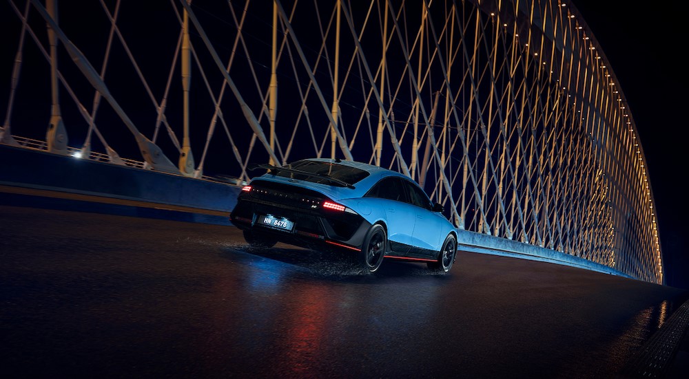 A blue 2026 Hyundai IONIQ 6 N driving on a bridge.