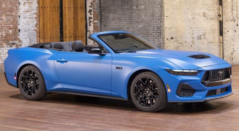 A blue 2025 Ford Mustang parked at a Ford dealer.