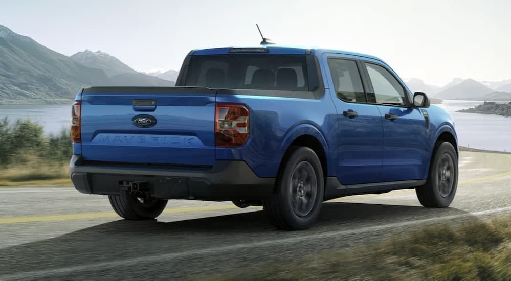 A blue 2025 Ford Maverick driving to a Ford dealer.