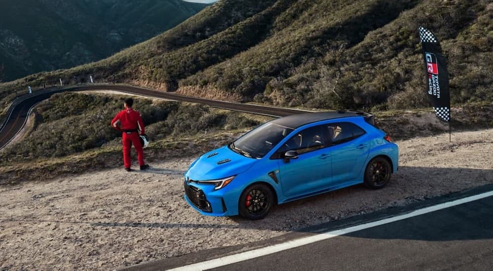 A blue 2024 Toyota GR Corolla parked near a flag.