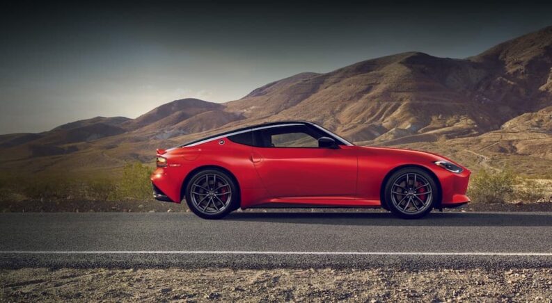 A red 2025 Nissan Z parked on a highway.