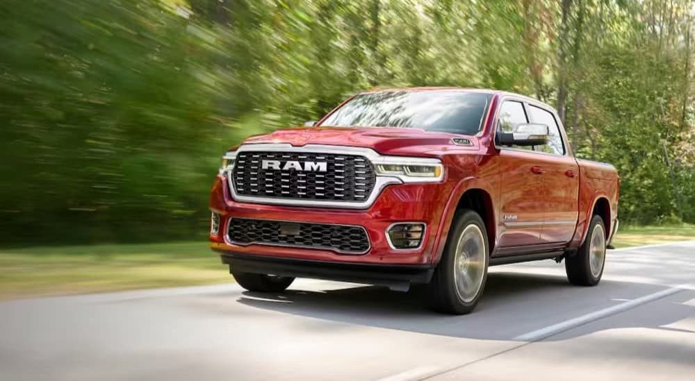A red 2026 Ram 1500 driving on a highway.