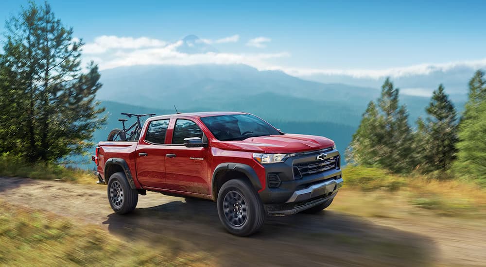 A red 2025 Chevy Colorado off-roading on a trail