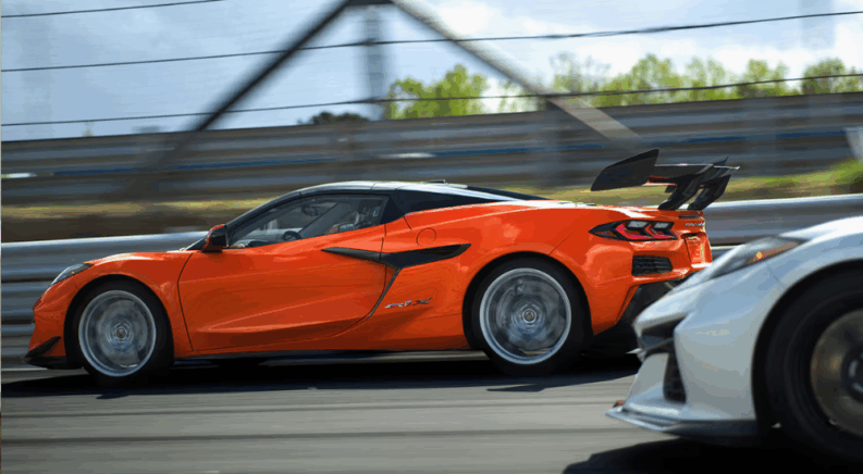 Orange 2026 Chevy Corvette ZR1X from the side driving around a track.