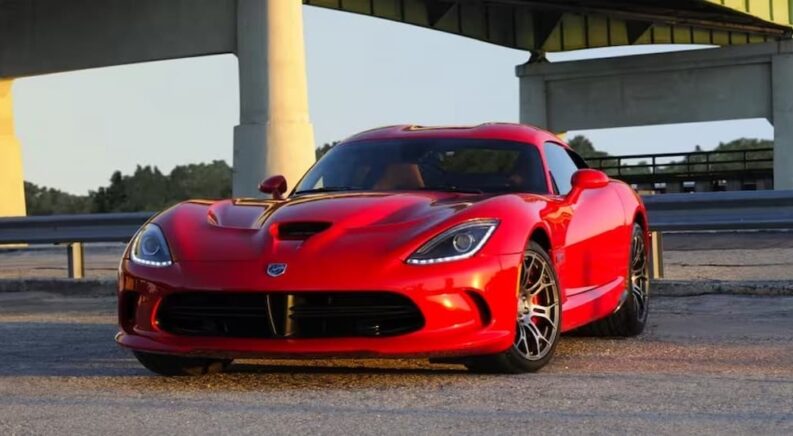 A red 2017 Dodge Viper SRT parked under an overpass after visiting a used car dealer.