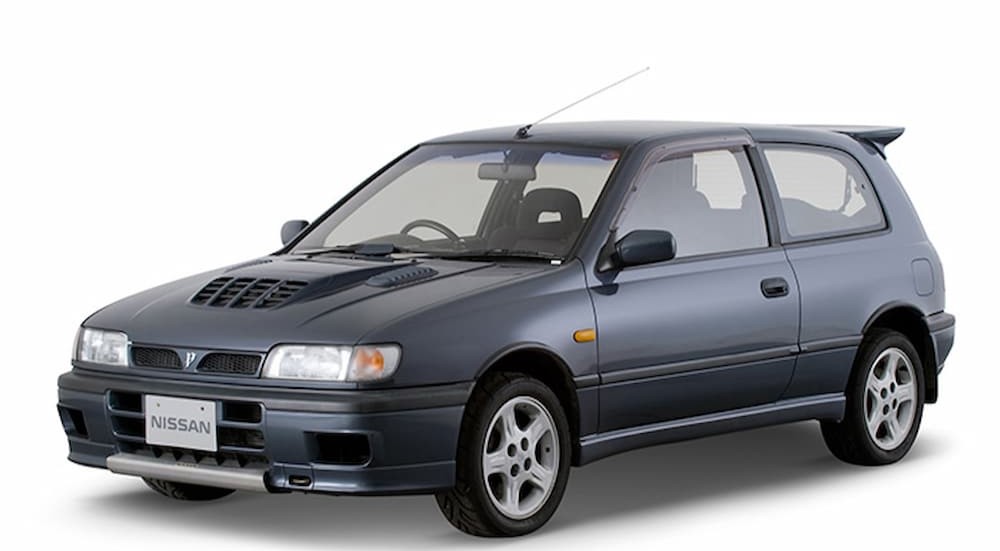 A gray 1990 Nissan Pulsar GTi-R parked in a showroom.
