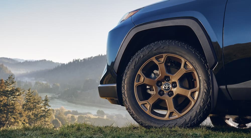Gold rim and tire on a blue 2026 RAV4 Woodland parked for sale