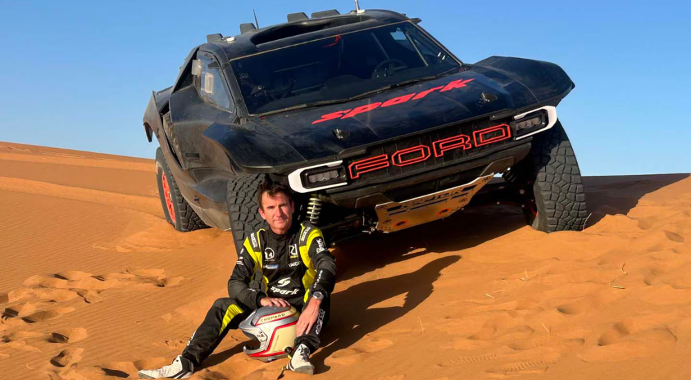 Romain Dumas sitting in front of his Ford Raptor T1+