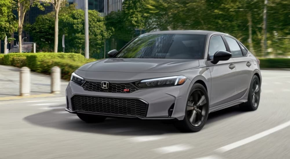 A gray 2025 Honda Civic Si driving in a city.