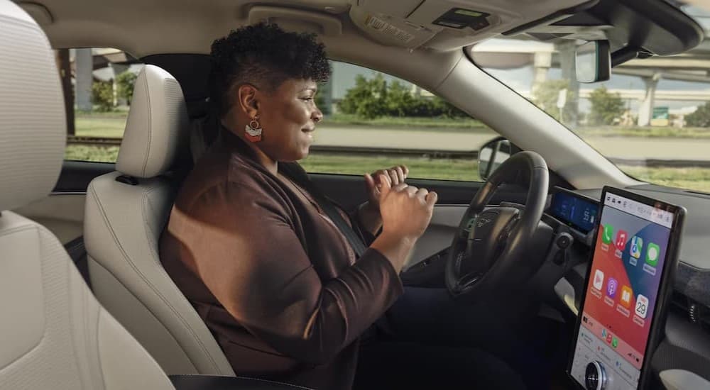 A person driving to a Ford dealer in a 2025 Ford Mustang Mach-E.