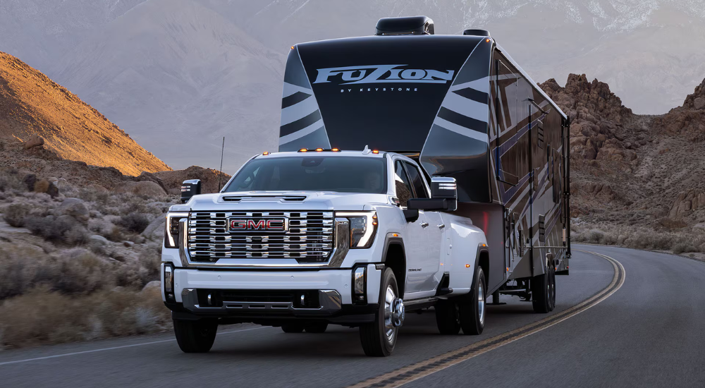 White 2025 GMC Sierra 3500 HD towing a camper