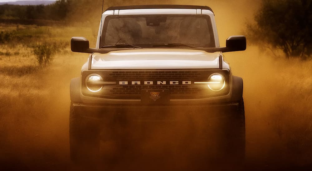 A white 2026 Ford Bronco Outer Banks off-roading in dirt