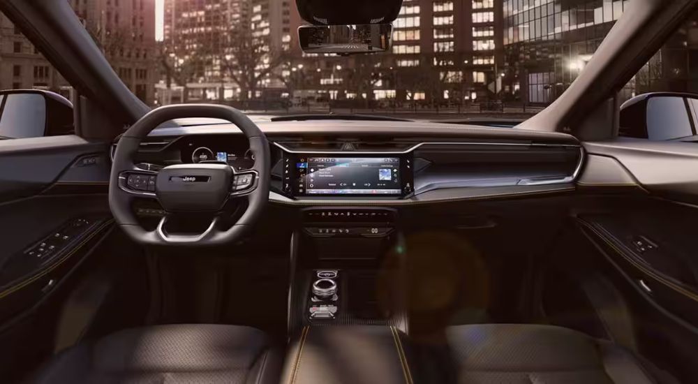 Interior view of a 2026 Jeep Cherokee infotainment, steering wheel and digital gauge cluster.