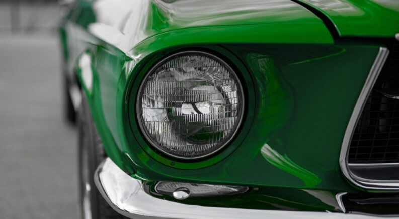 Green 1968 Ford Mustang GT close up of the headlight.