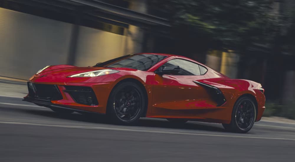 A red 2026 Chevy Corvette Stingray driving in a city