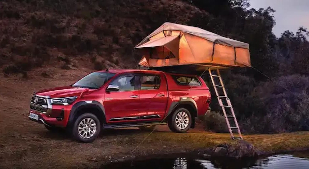 A red 2026 Toyota Hilux parked offroad.