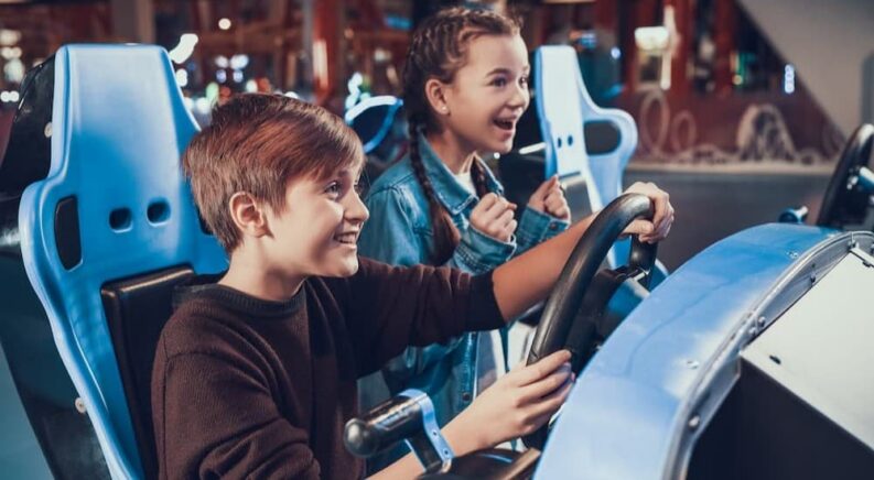 Two children playing a racing sim.