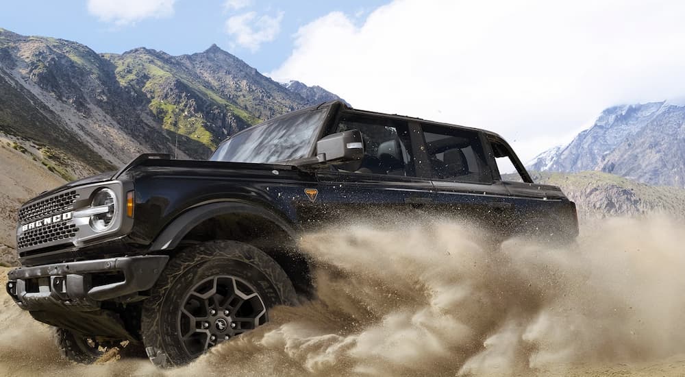 A black 2026 Ford Bronco Badlands driving in sand