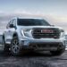 A white 2024 GMC Acadia AT4 is shown from the front at an angle.