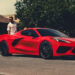 A red 2025 Chevy Corvette Stingray is shown after leaving a Chevy dealer.