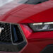 The front end of a red 2024 Ford Mustang at a Ford dealer.