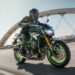 A green 2024 Kawasaki Z900 is shown riding on a bridge after visiting a motorcycle dealer.