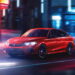 A red 2025 Honda Civic Hybrid Sport Touring driving through a city.