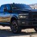 A black 2025 Ram 2500 Rebel parked in a desert area.