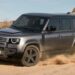 A gray 2025 Land Rover Defender 110 off-roading on sand.