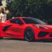 A red 2025 Chevy Corvette Stingray parked on a driveway after visiting a Chevy dealer.
