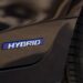 Close-up of blue hybrid badge on a black car