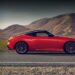 A red 2025 Nissan Z parked on a highway.