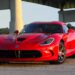 A red 2017 Dodge Viper SRT parked under an overpass after visiting a used car dealer.
