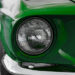 Green 1968 Ford Mustang GT close up of the headlight.