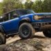 A blue 2025 Ford Bronco Raptor off-roading.