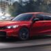 A red 2026 Honda Civic SI driving in a city.
